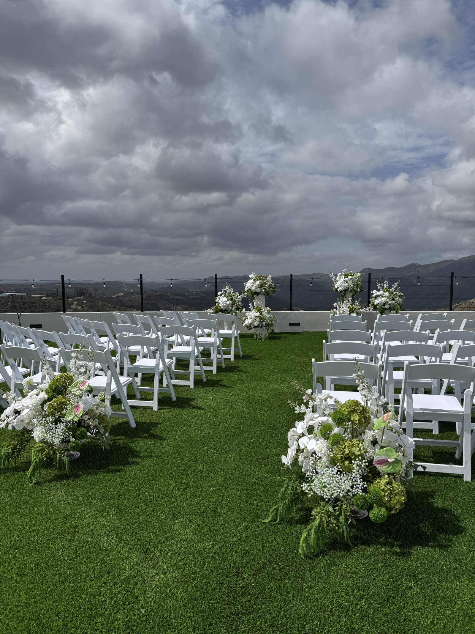 Wide ceremony shot with floral arch at the Farley wedding