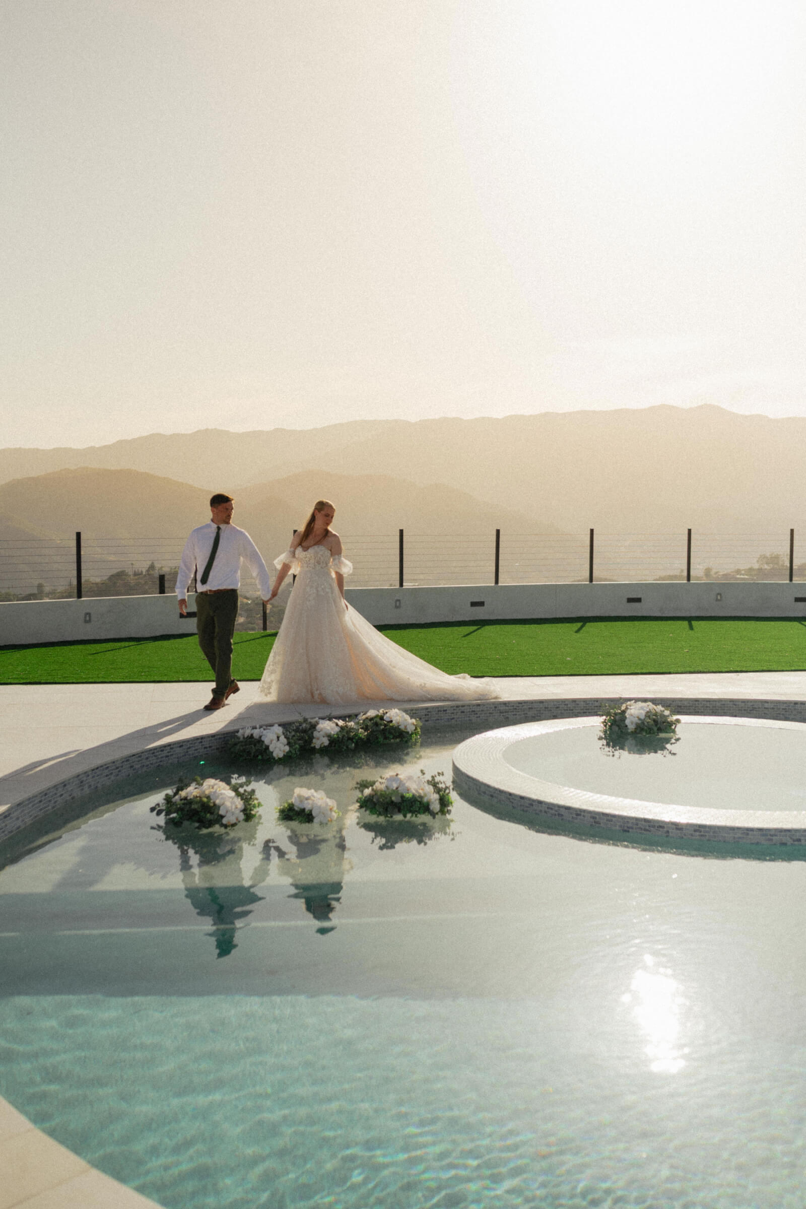 Wide shot of floating bouquets across a wedding pool